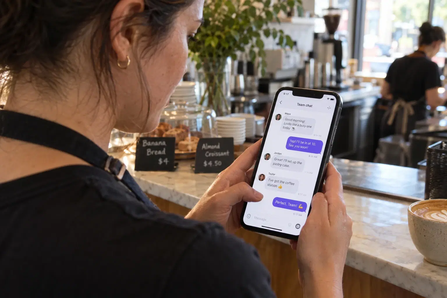 Restaurant employee checking team messages on a phone